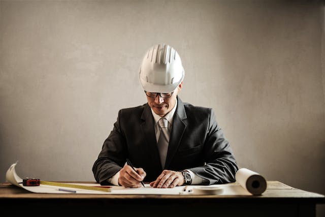 Un profesional con casco y escribiendo.