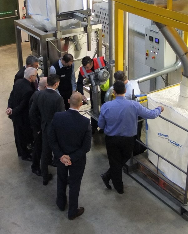 People at a production facility examining a conveyor system