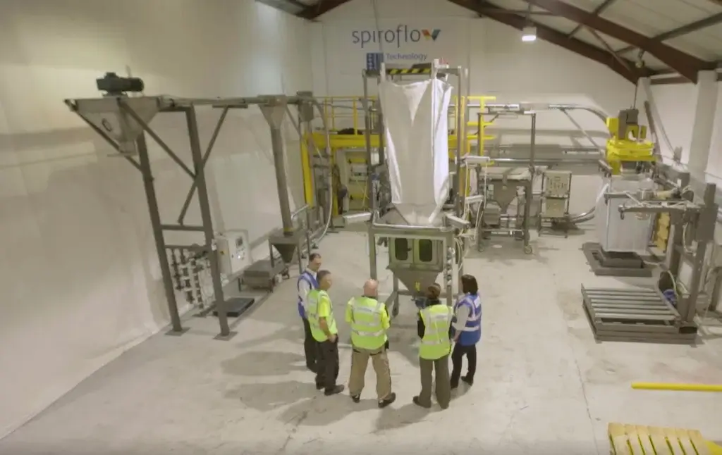 A group of professionals testing a Spiroflow bulk bag filler 